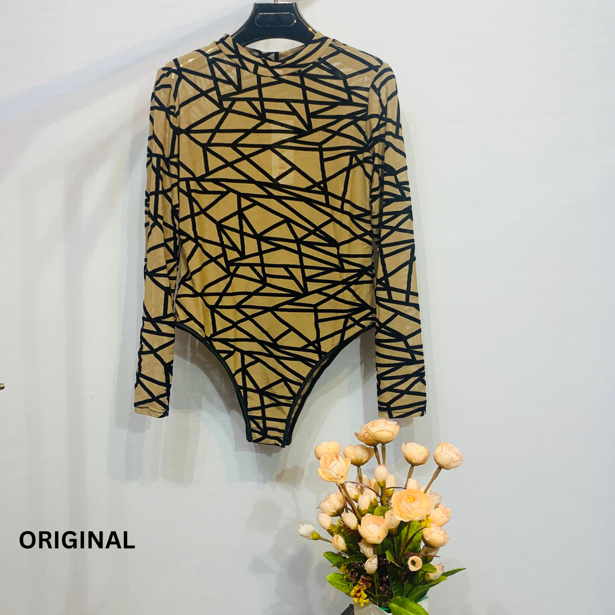 This bodysuit features a geometric print pattern
