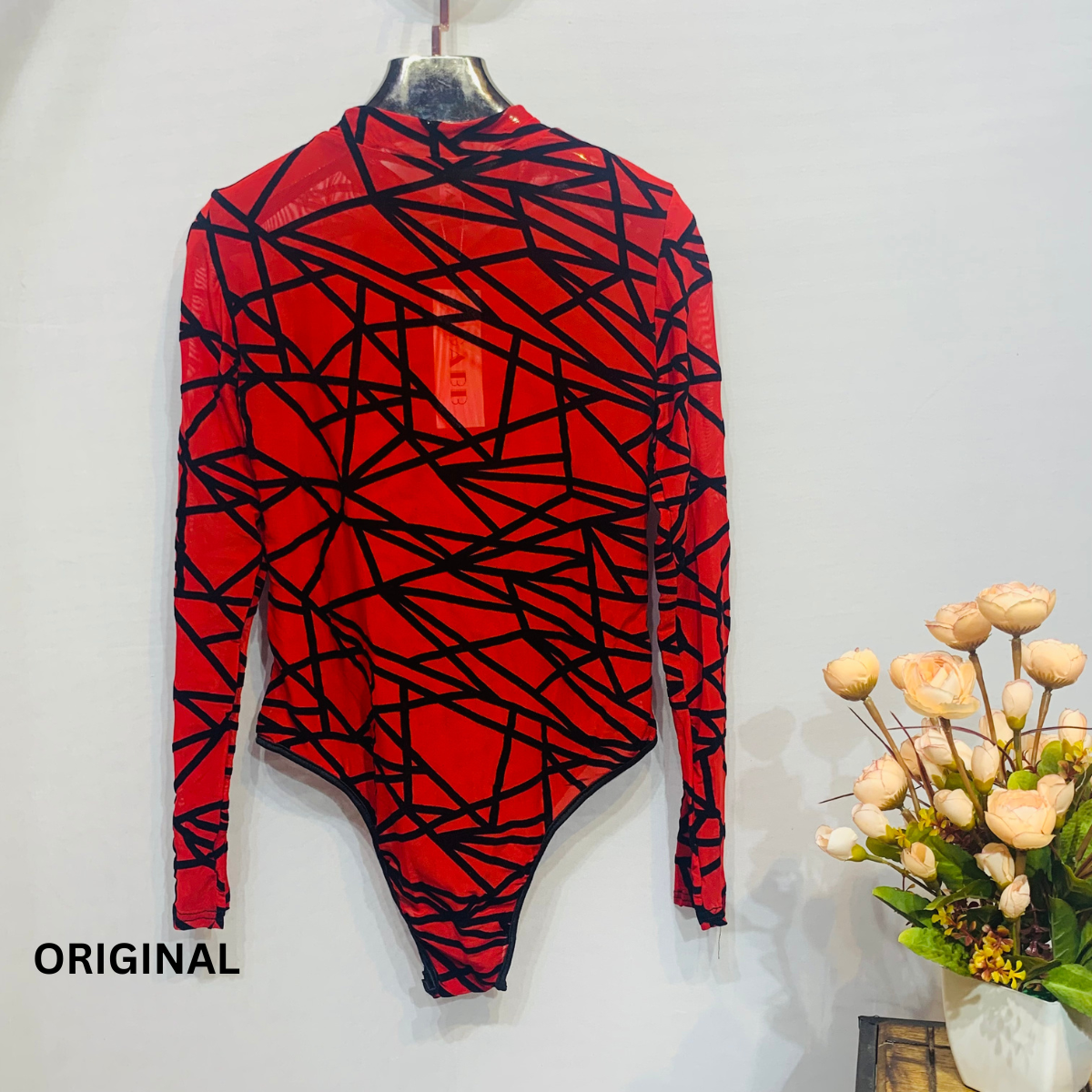 This bodysuit features a geometric print pattern